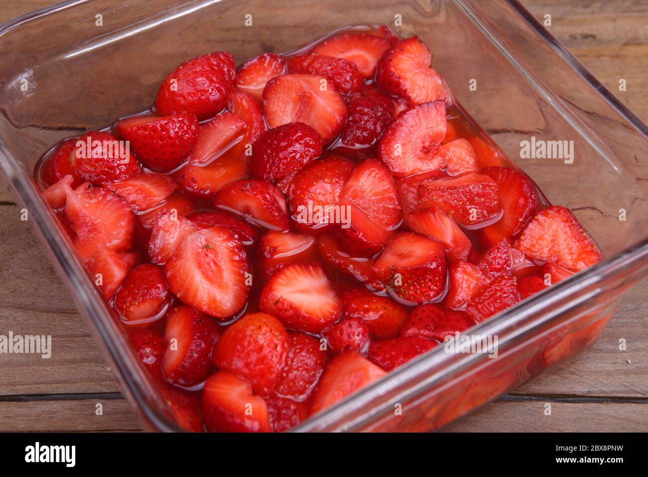 fraises dans un pot en verre sur une table en bois Banque D'Images