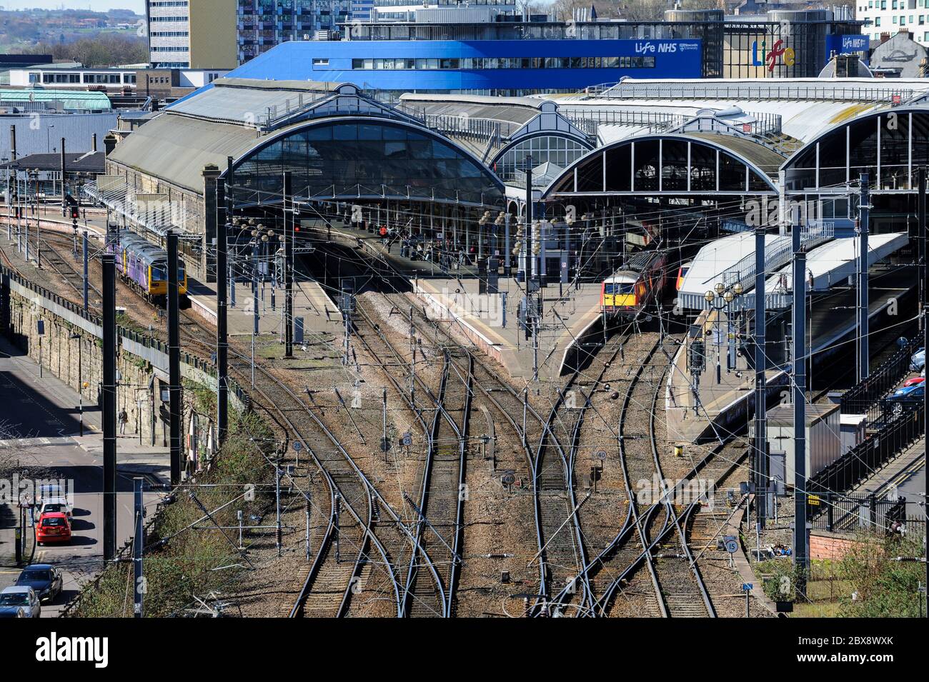 Vue surélevée de la gare centrale de Newcastle ; trains sur les plates-formes ; rails et câbles électriques aériens en premier plan ; NHS Center for Life en arrière-plan. Banque D'Images