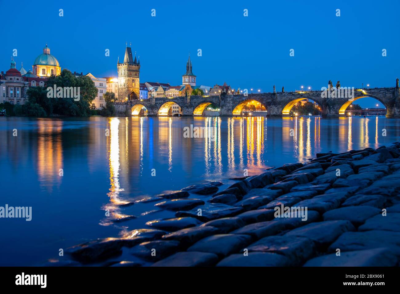 Pont Charles illuminé se reflétant dans la rivière Vltava. Soirée à Prague, République tchèque. Banque D'Images