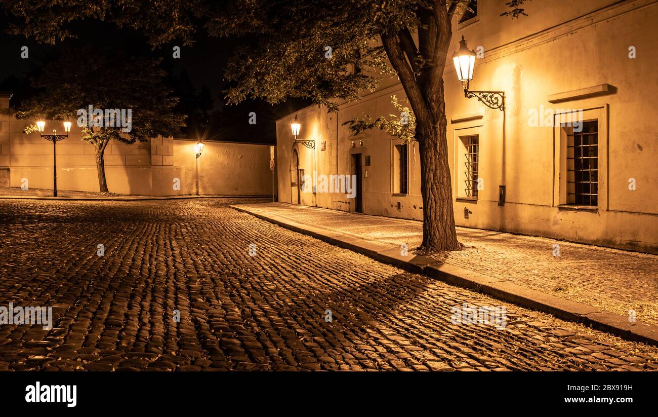 Petite rue pavée dans la vieille ville médiévale avec maisons illuminées par des lampes de rue d'époque, Novy svet, Prague, République tchèque. Prise de vue de nuit. Banque D'Images