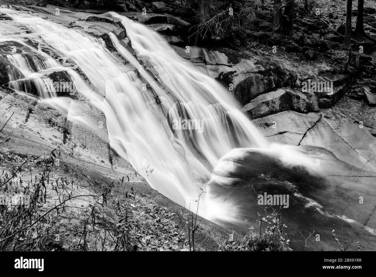Cascade de Mumlava en automne, Harrachov, montagnes géantes, parc national de Krkonose, République tchèque. Image en noir et blanc. Banque D'Images