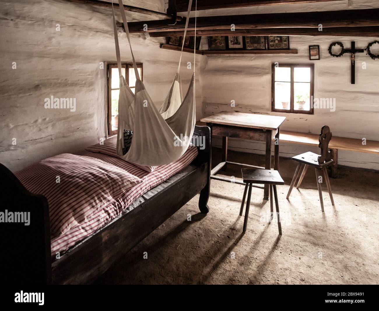 Chambre vintage avec lit, table et chaises dans la maison rurale ancienne. Image de style sépia. Banque D'Images