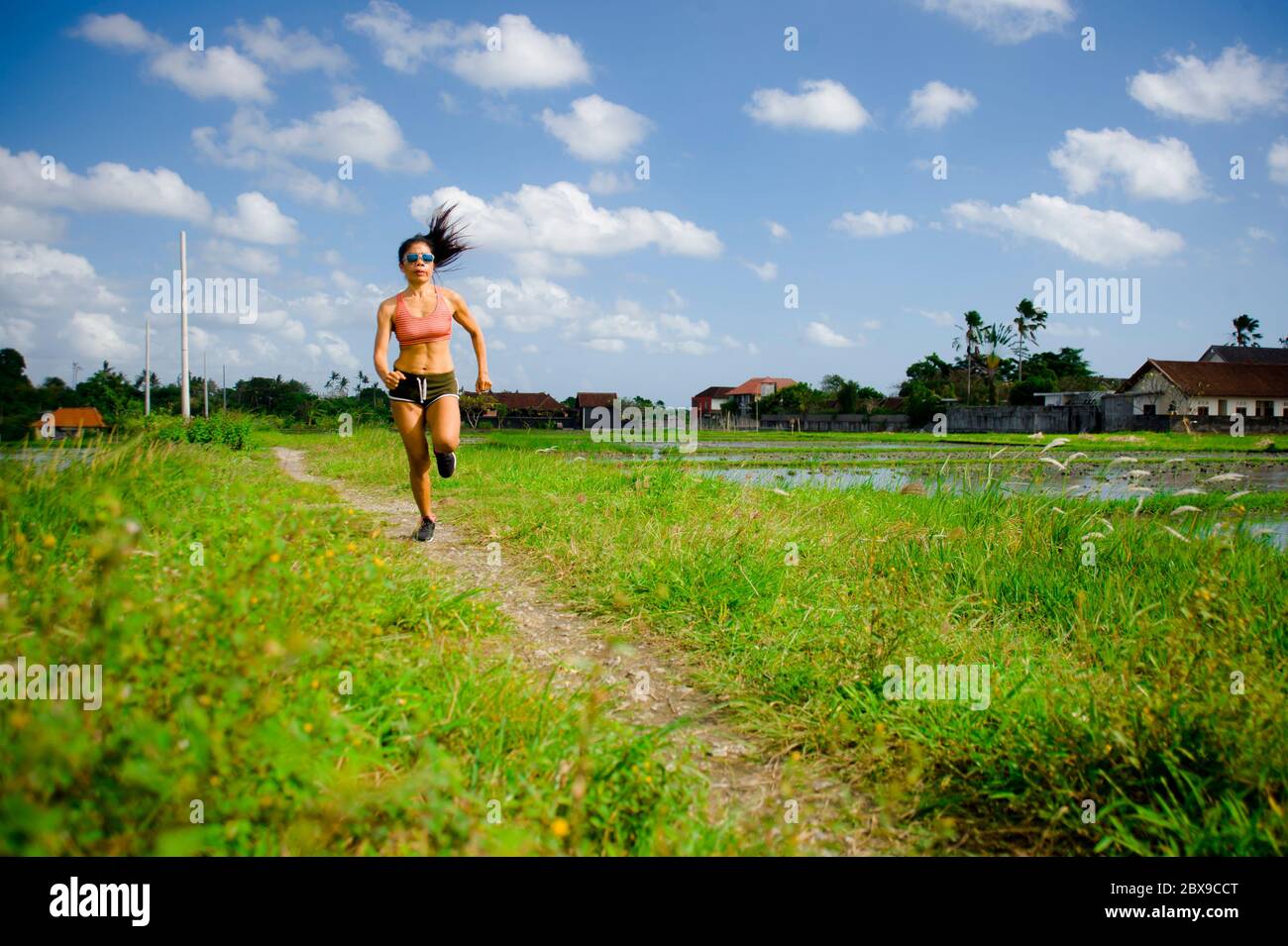 Attrayant et très en forme asiatique sport femme entraînement entraînement entraînement à la course à pied sur le terrain vert paysage arrière-plan travailler dur dans un style de vie sain et la compétition Banque D'Images