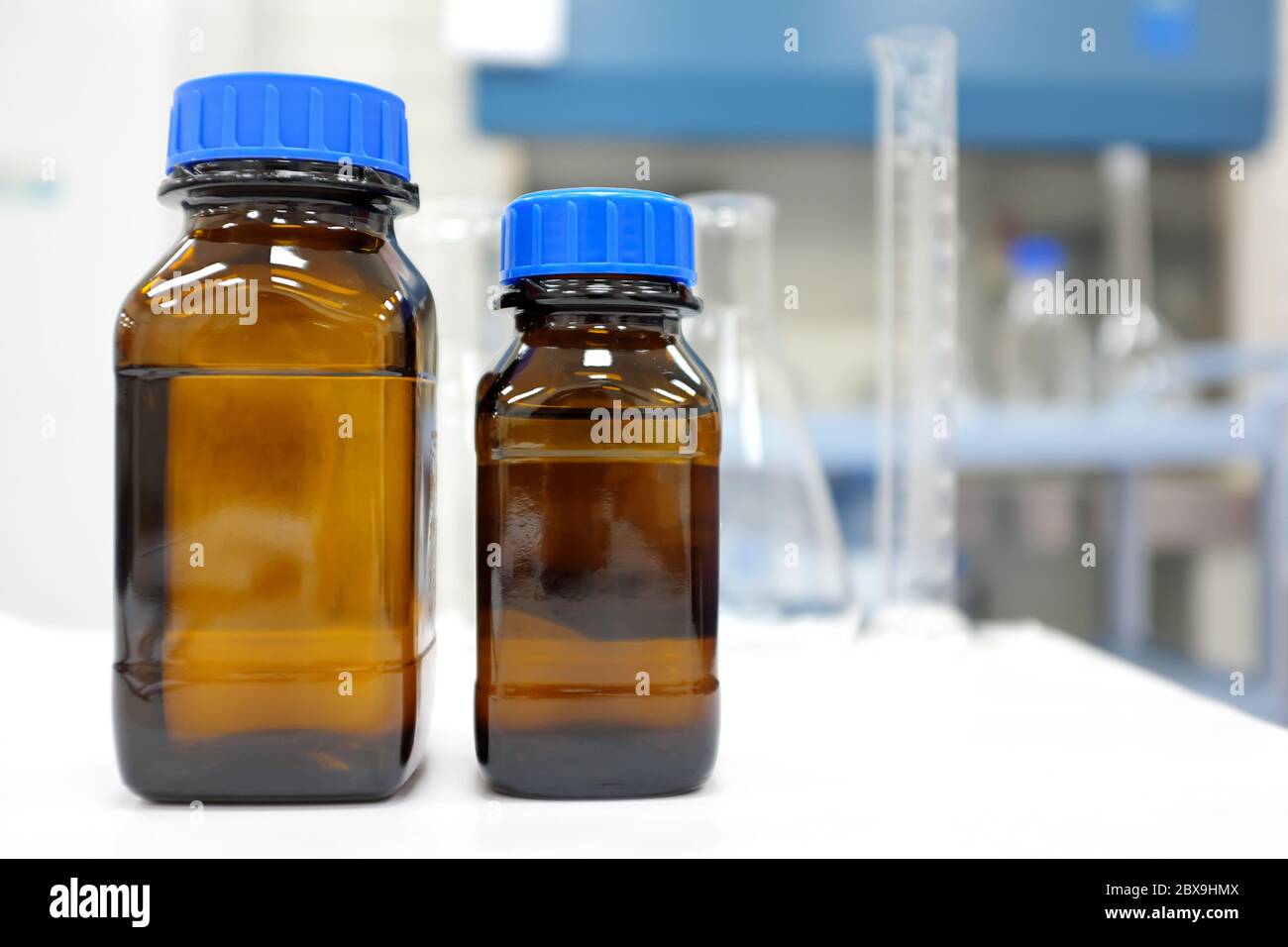 Pas d'étiquette flacon en verre ambré avec produit chimique liquide transparent dans un laboratoire avec espace de copie. Banque D'Images