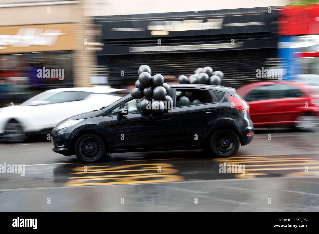 Leicester, Leicestershire, Royaume-Uni. 6 juin 2020. Une voiture décorée de ballons noirs passe devant une démonstration de « Black Lives Matter » après la mort de l'américain George Floyd alors qu'il était sous la garde de la police de Minneapolis. Credit Darren Staples/Alay Live News. Banque D'Images