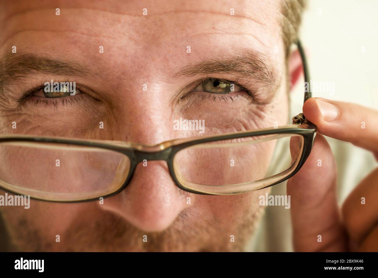 gros plan portrait du visage de l'homme vérifiant la vision essayant des lunettes à l'optométriste . guy 40s pendant l'examen optique des lunettes de correction de la myopie Banque D'Images