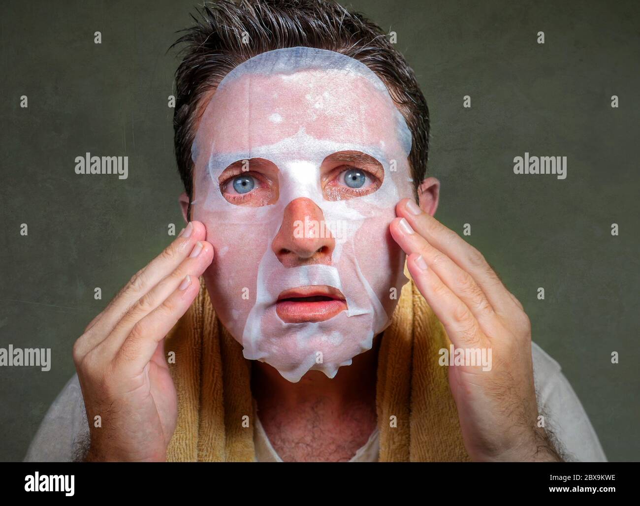 style de vie isolé portrait de fond de jeune étrange et drôle homme à la maison essayant d'utiliser le papier de beauté masque facial de nettoyage d'apprentissage anti vieillissement traitm Banque D'Images