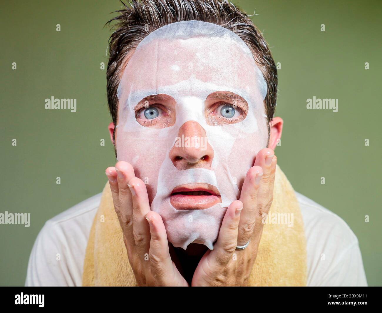 style de vie isolé portrait de fond de jeune étrange et drôle homme à la maison essayant d'utiliser le papier de beauté masque facial de nettoyage d'apprentissage anti vieillissement traitm Banque D'Images