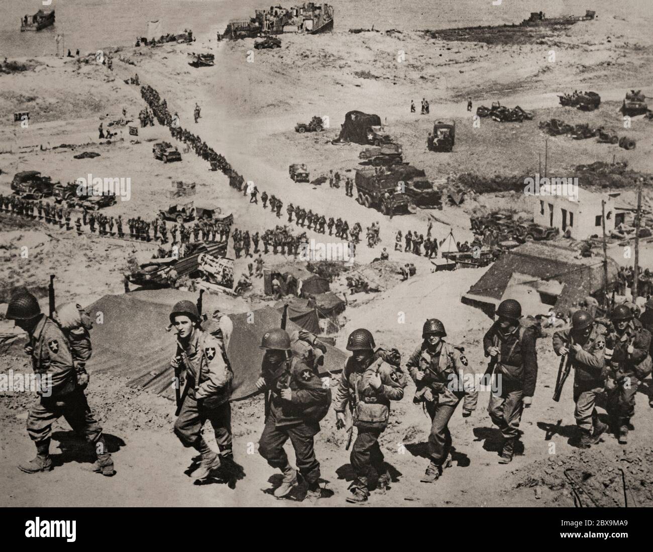 Des fantassins américains qui ont déposé leur tête de plage en juin 1944 pour participer à l'invasion de la Normandie par les alliés dans l'opération Overlord pendant la Seconde Guerre mondiale Nommé opération Neptune et souvent appelé jour J, il s'agissait de la plus grande invasion maritime de l'histoire. L'opération a commencé la libération de la France occupée par l'Allemagne (et plus tard l'Europe occidentale) et a posé les bases de la victoire des alliés sur le Front occidental. Banque D'Images