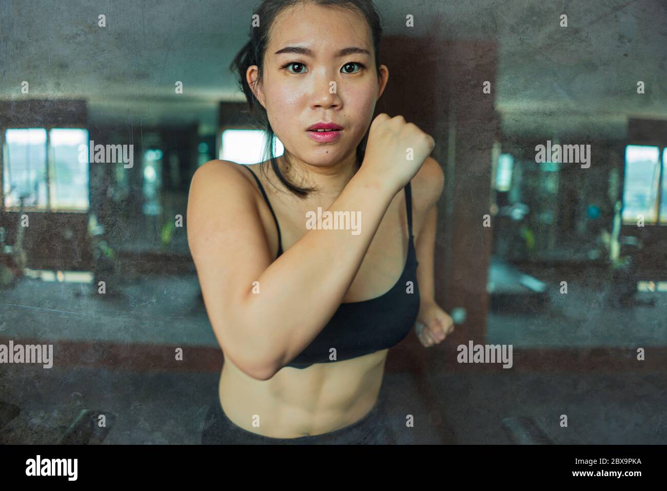 Jeune femme asiatique attirante et en forme de coréenne faisant de l'entraînement à la salle de gym de l'hôtel ou au club de fitness jogging dans l'entraînement de tapis roulant dur dans un style de vie sain Banque D'Images