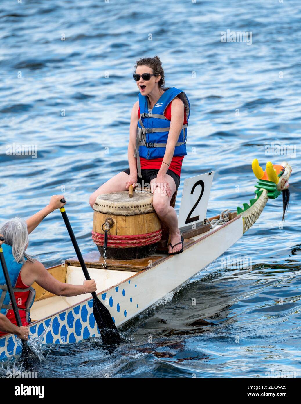 Saint John, Nouveau-Brunswick, Canada - 26 août 2017 : événements au Festival des bateaux-dragons. Un batteur bat le temps à l'avant. Les gens sont à la ligne du bateau. Banque D'Images