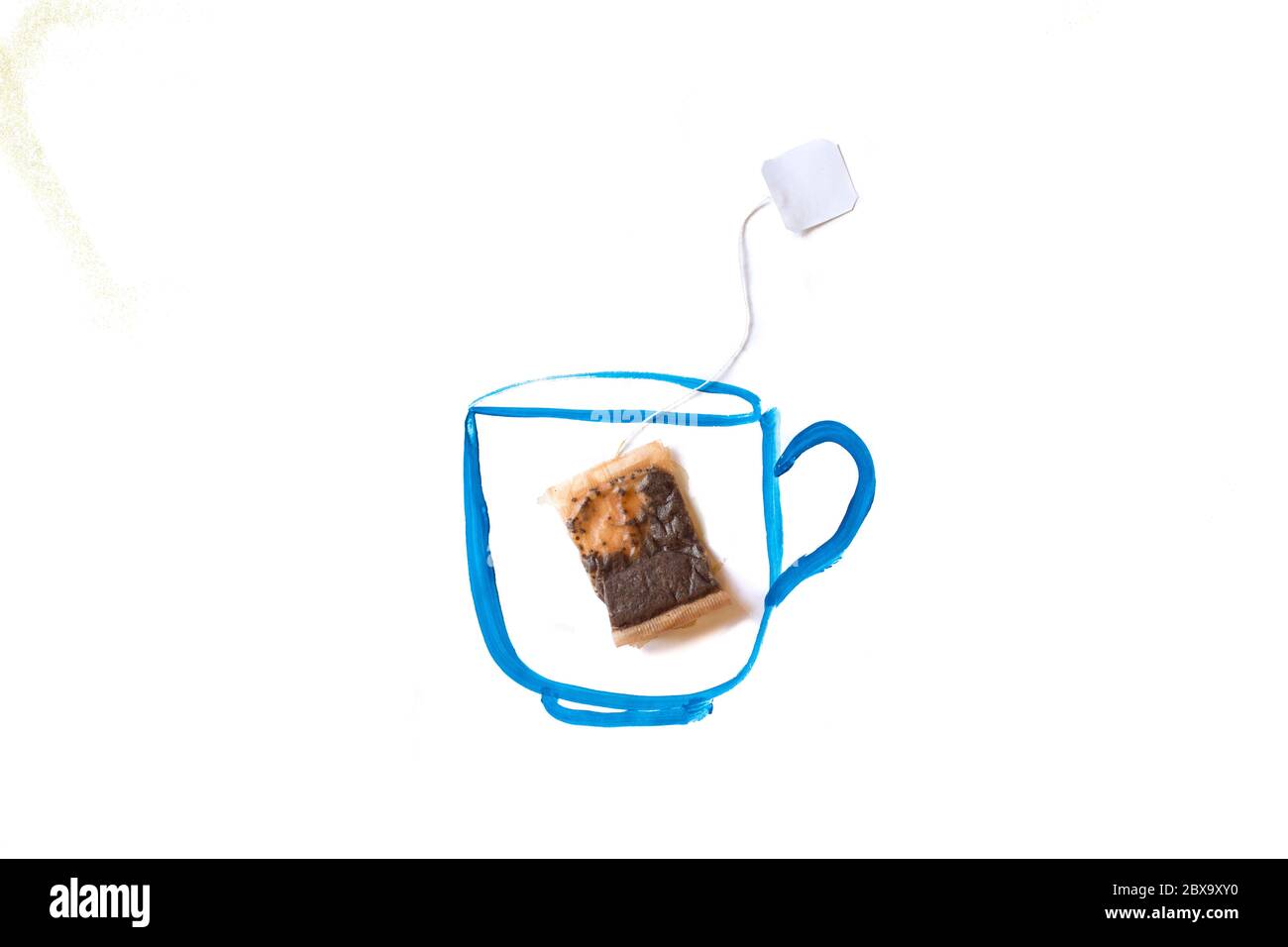 sac de thé dans un mug peint bleu, fond blanc Banque D'Images