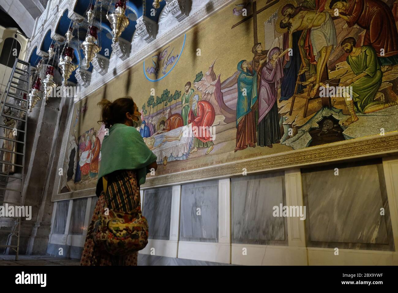 Un visiteur voit une mosaïque murale représentant le corps de Jésus Christ préparé après sa mort, face à la Pierre d'onction à l'intérieur de l'Église du Saint-Sépulcre dans la vieille ville chrétienne Jérusalem-est Israël Banque D'Images