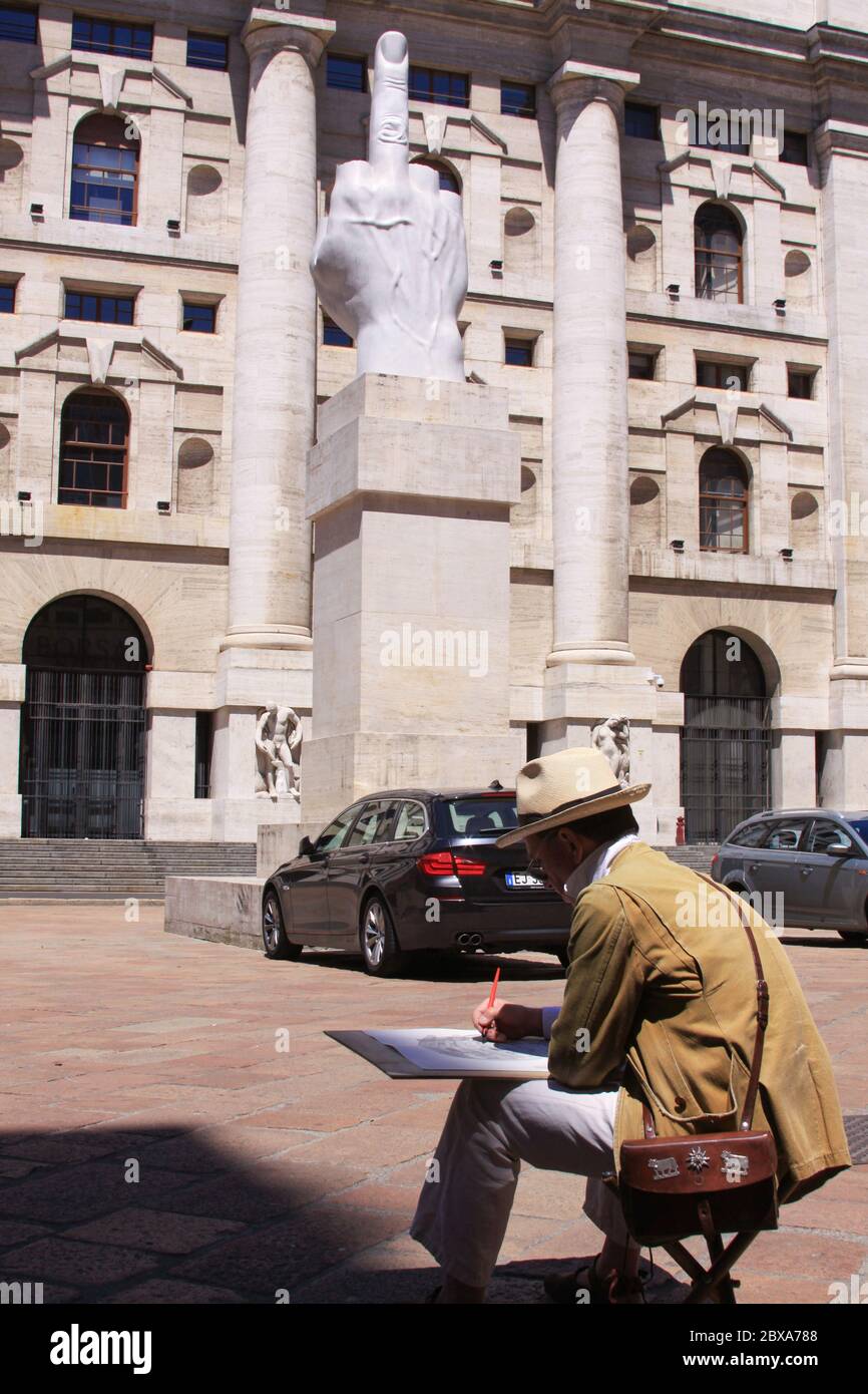 MILAN, ITALIE - 26 mai 2013 : artiste de rue peignant la statue du doigt du milieu à Milan, Italie, devant le siège de la Bourse, sur la Piazza Banque D'Images