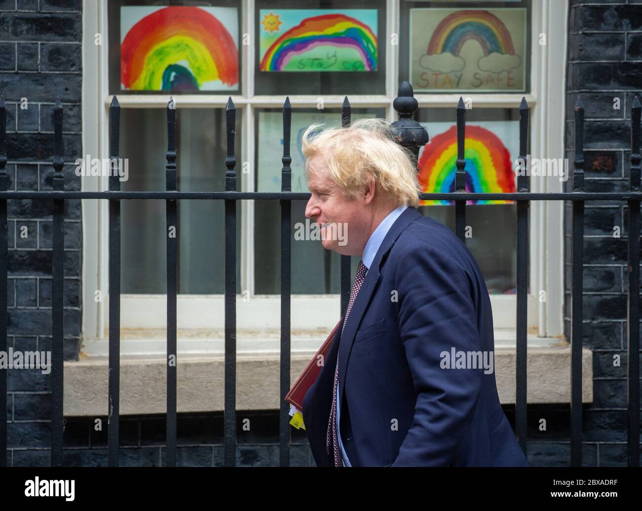 Le Premier ministre, Boris Johnson, passe devant des photos arc-en-ciel dessinées par des enfants pour montrer son soutien aux travailleurs du NHS qui luttent contre la pandémie du coronavirus. Banque D'Images