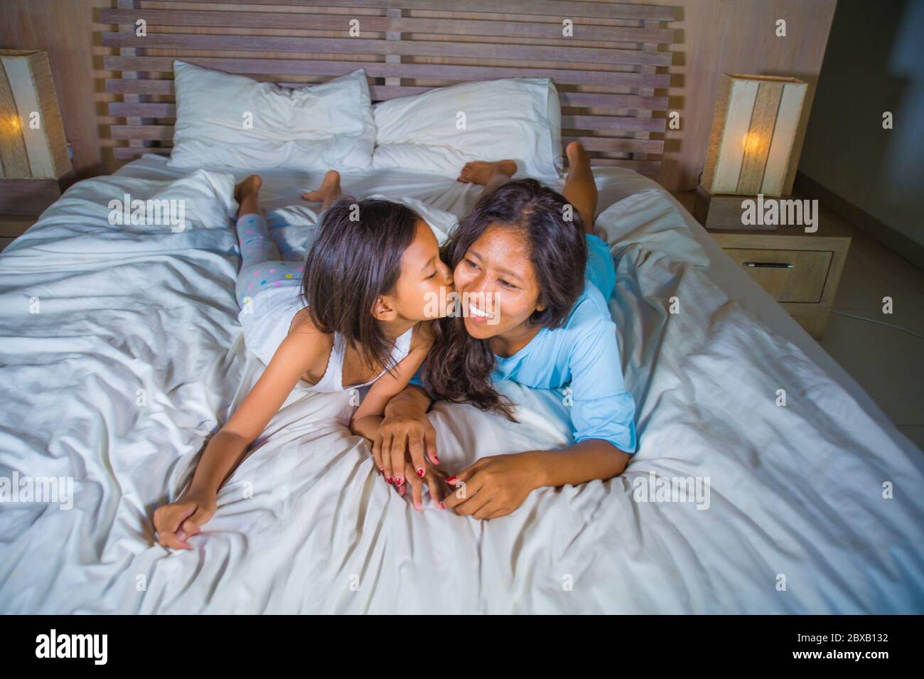 Portrait de la chambre de style de vie d'une femme asiatique heureuse à la maison posant avec sa belle fille de 8 ans dans le lit souriant ludique gai en mère et Banque D'Images
