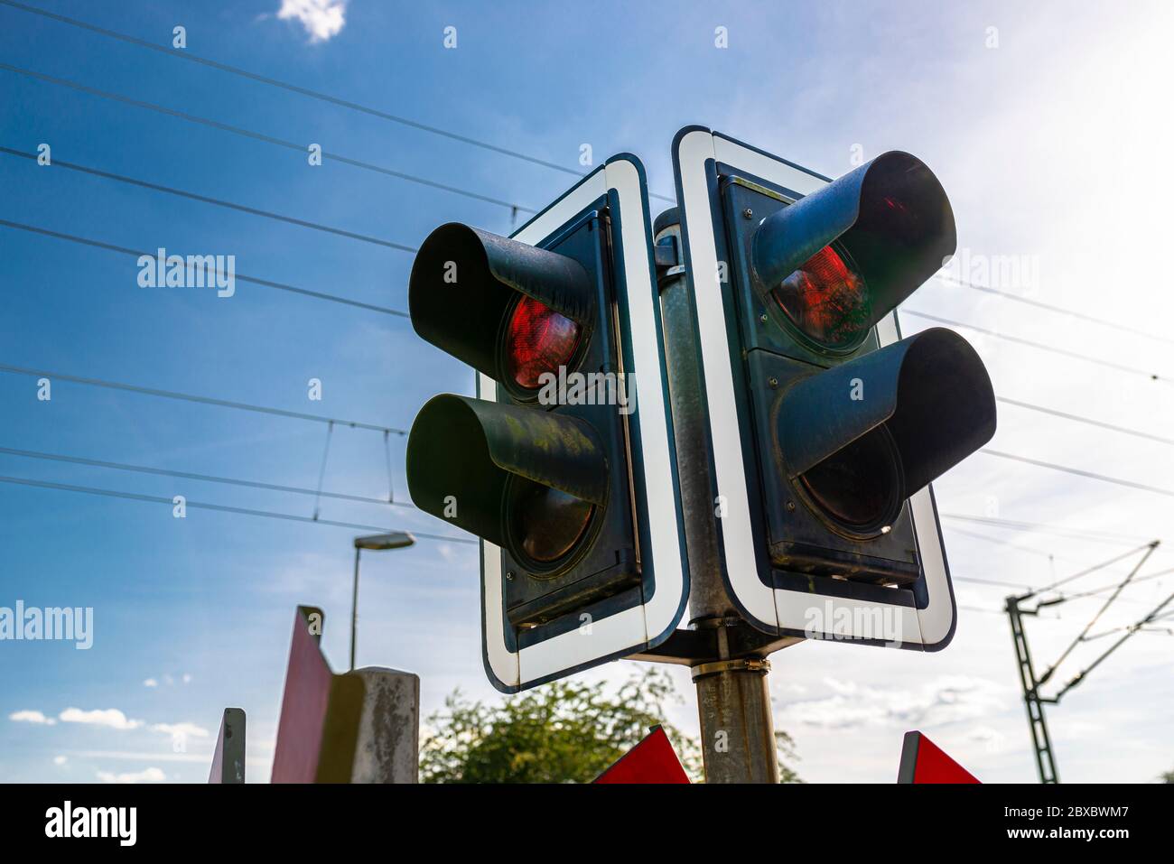 Feux de signalisation avant le passage à niveau avec un feu rouge pour avertir de l'approche des trains. Banque D'Images