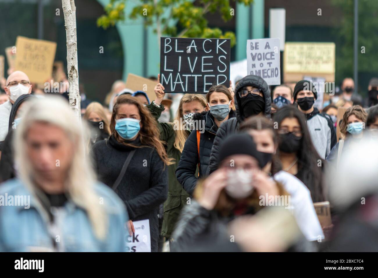 Black Lives Matter contre le racisme manifestation de protestation à Southend on Sea, Essex, Royaume-Uni. Plaque BLM tenue par une femelle blanche de race blanche. Masques, foule Banque D'Images