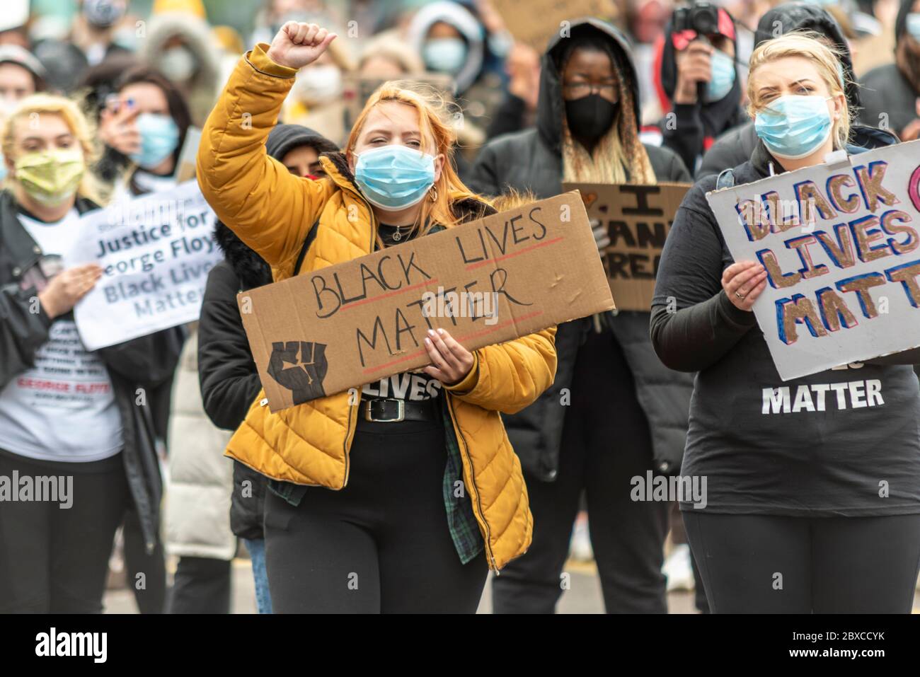 Black Lives Matter contre le racisme manifestation de protestation à Southend on Sea, Essex, Royaume-Uni. Étiquette de maintien blanche blanche pour femme avec poing relevé Banque D'Images