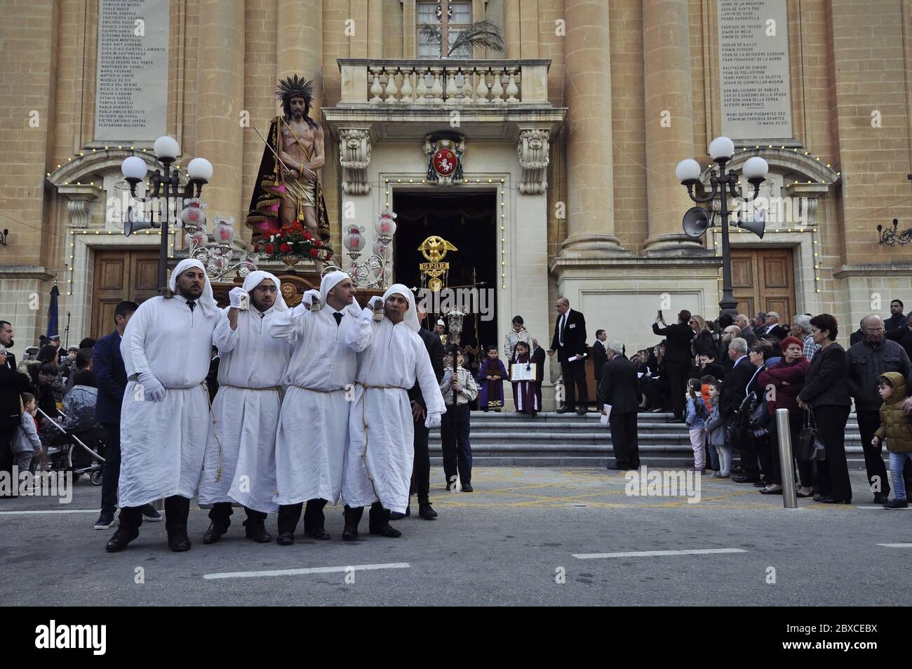 Porteurs de la scène avec la statue de Jésus Christ, approchant de la caméra. Ils portent des robes blanches sur le côté gauche de l'image. Banque D'Images