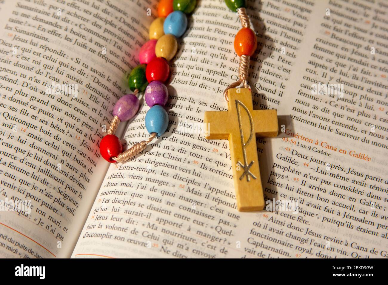 Un rosaire dans une Bible ouverte en français. Banque D'Images