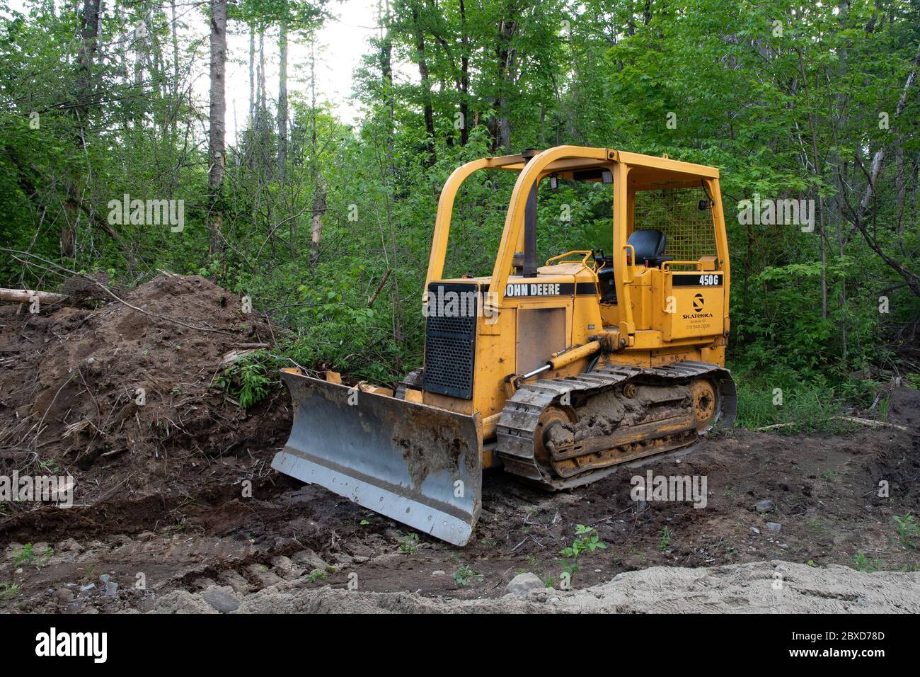 Un tracteur à chenilles John Deere 450G stationné sur une route forestière dans la nature sauvage des montagnes Adirondack, NY USA Banque D'Images