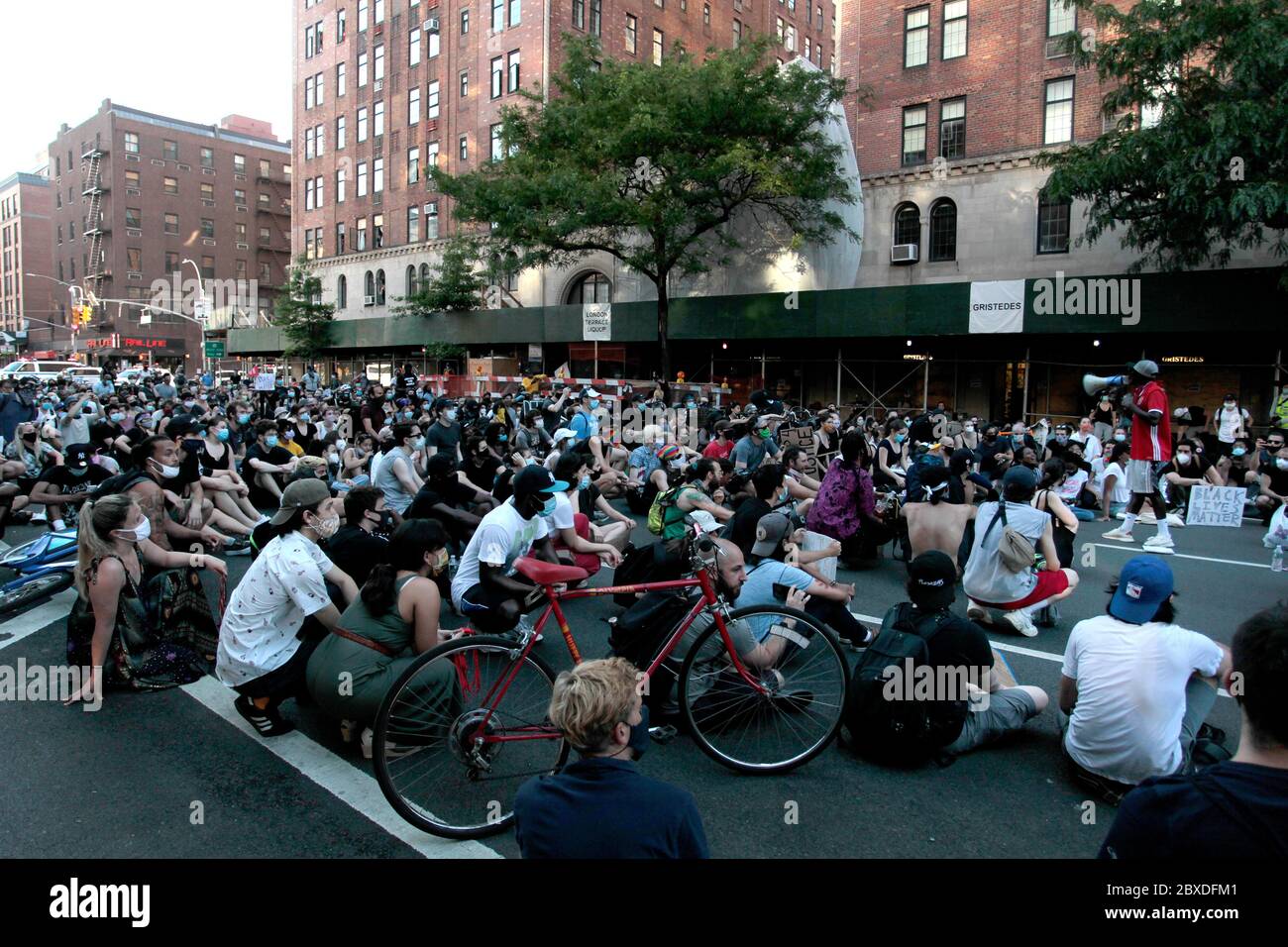 New York, New York, États-Unis. 6 juin 2020. Les manifestants défilant en réponse à la mort de George Floyd, afro-américain, alors qu'ils sont sous la garde de la police de Minneapolis et en soutien au mouvement Black Lives Matter, s'assoient sur le trottoir au coin de la 9e Avenue et de la 23e rue ouest dans le quartier de Chelsea à Manhattan aujourd'hui. Il s'agissait d'une des centaines de manifestations aux États-Unis et dans le monde entier en réponse à la mort de Floyd la semaine dernière. Crédit : Adam Stoltman/Alamy Live News Banque D'Images