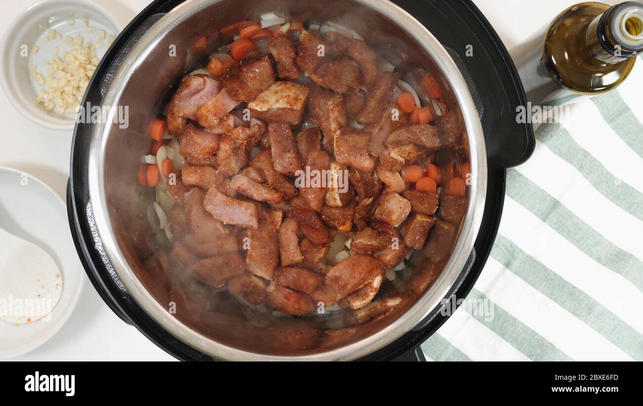 Cuisez du riz avec de la viande et des légumes dans le cuiseur multifonction sous pression étape par étape. Ajouter la viande hachée marinée. Banque D'Images