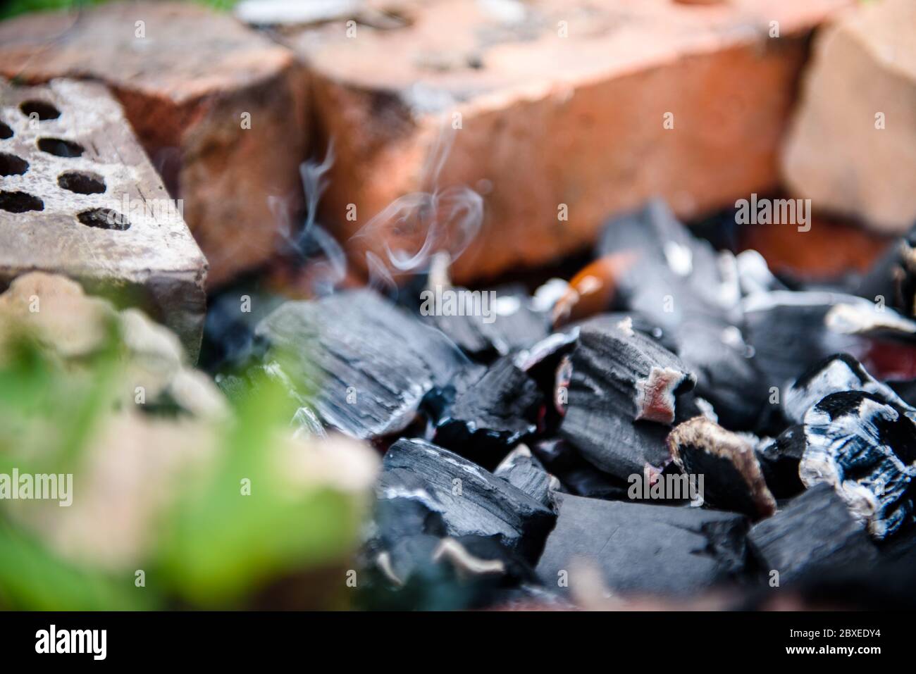 Les empères d'un feu mort fumage dans la clôture en briques. Le feu après le barbecue. Banque D'Images