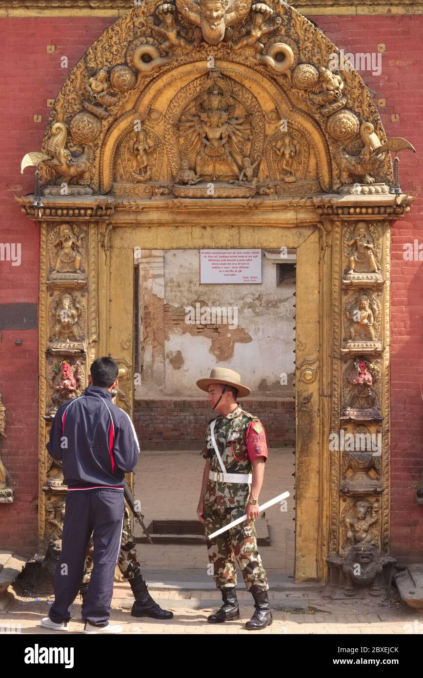 Un soldat népalais garde à l'entrée décorée de façon ornée de l'ancien palais royal de Durbar Square, Bhaktapur, dans la vallée de Katmandou, au Népal Banque D'Images