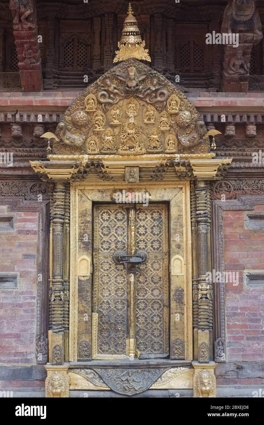 Une porte dorée ornée surmontée d'une torana dorée, à Mul Chowk, dans le complexe du palais royal de Durbar Square, Patan (Lalitpur), Katmandou Valley, Népal Banque D'Images