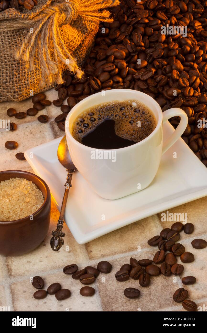 Tasse de café - le café est une boisson brassée préparée à partir des graines grillées de plusieurs espèces d'un arbuste à feuilles persistantes du genre Coffea. Banque D'Images