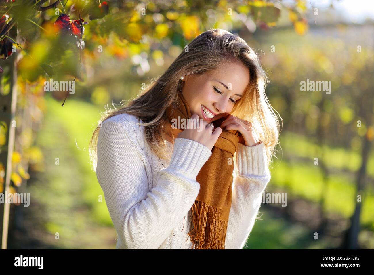 Femme souriante profitant du soleil d'automne à la campagne Banque D'Images