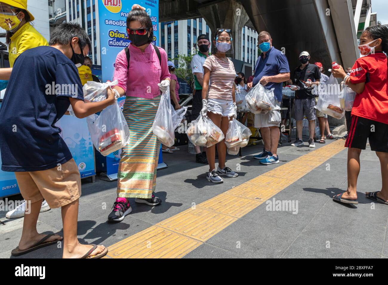 Faites du bénévolat avec un masque facial et des gants en donnant de la nourriture gratuite à la banque alimentaire pendant la pandémie de Covid, Bangkok, Thaïlande Banque D'Images