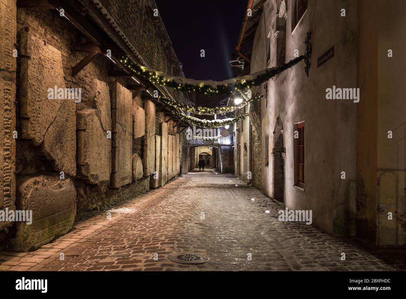 Vue sur le passage de Sainte-Catherine à Tallinn la nuit. Les pierres tombales sont visibles sur le côté gauche. Banque D'Images
