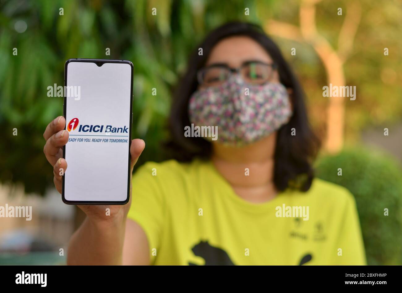 New Delhi, Inde, 2020. Fille portant un masque facial montrant l'application de banque ICICI pendant une pandémie de la maladie de Corona virus (Covid-19). Les gens sont encouragés à ne pas v Banque D'Images
