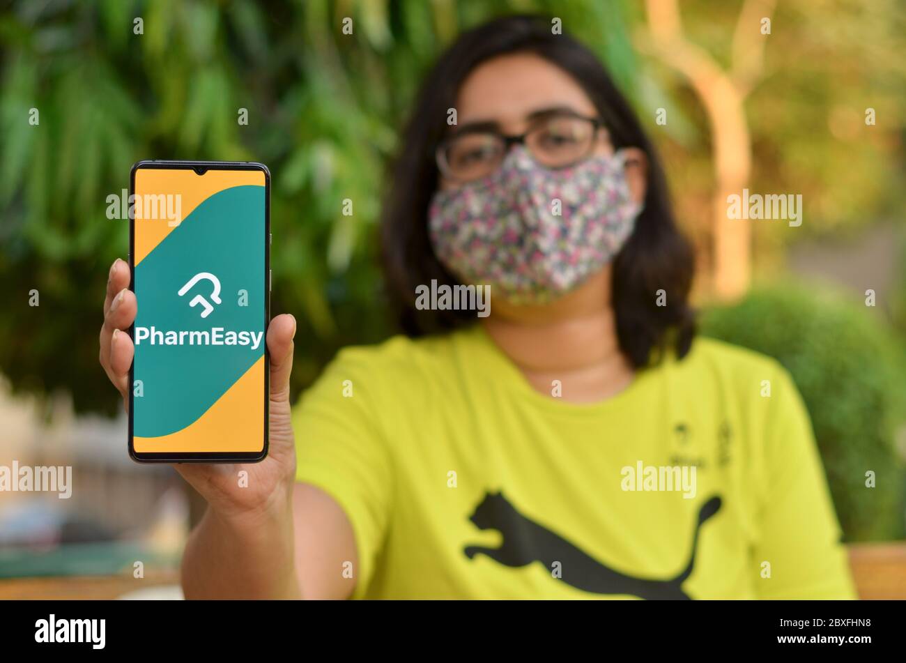 New Delhi, Inde, 2020. Fille portant un masque avec l'application Pharmesy sur le téléphone mobile. Seuls les services/produits essentiels sont autorisés à être livrés pendant toute la durée de l'offre Banque D'Images