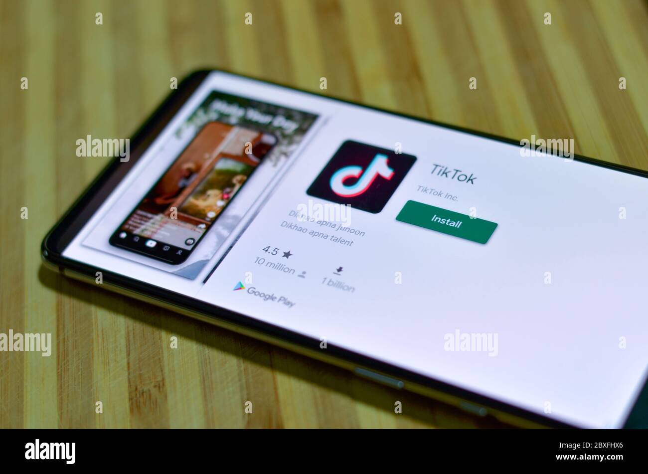 Delhi, Inde, 2020. Installation de l'application mobile TikTok sur un smartphone sur un fond en bois représentant le logo du site de réseau social populaire en pleine croissance Banque D'Images