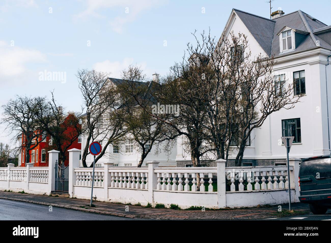 Maison au coin de la rue, avec une belle clôture blanche avec des colonnes à Reykjavik, la capitale de l'Islande. Banque D'Images