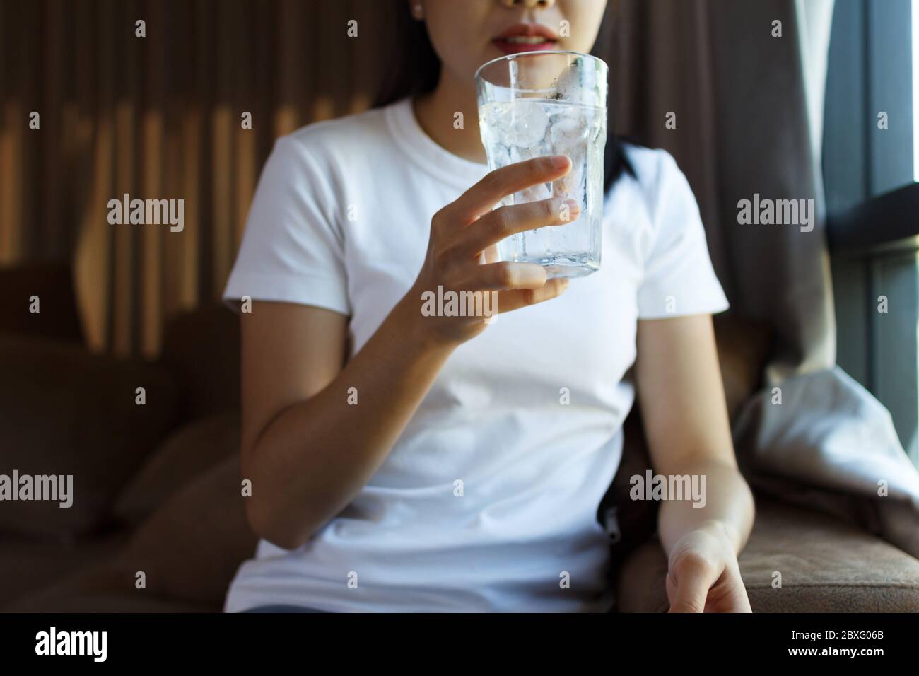 Gros plan de la consommation d'eau par une femme. Concept de soins de santé Banque D'Images
