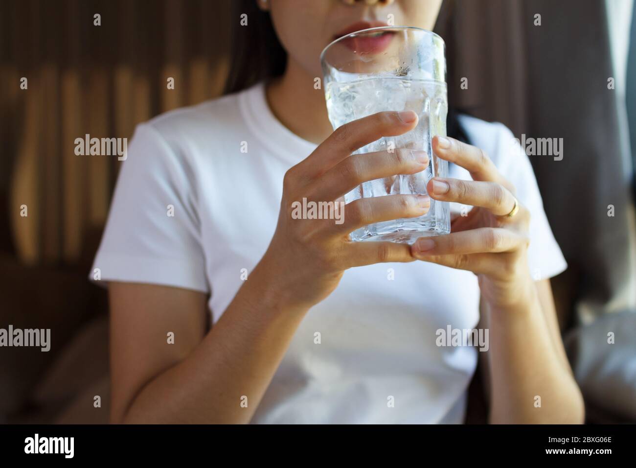 Gros plan de la consommation d'eau par une femme. Concept de soins de santé Banque D'Images
