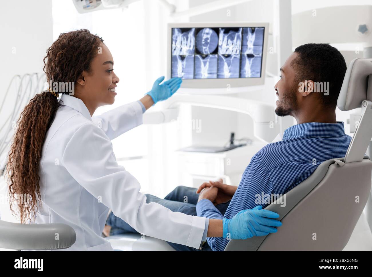 Femme africaine dentiste pointant à l'écran avec l'image de rayons X. Banque D'Images