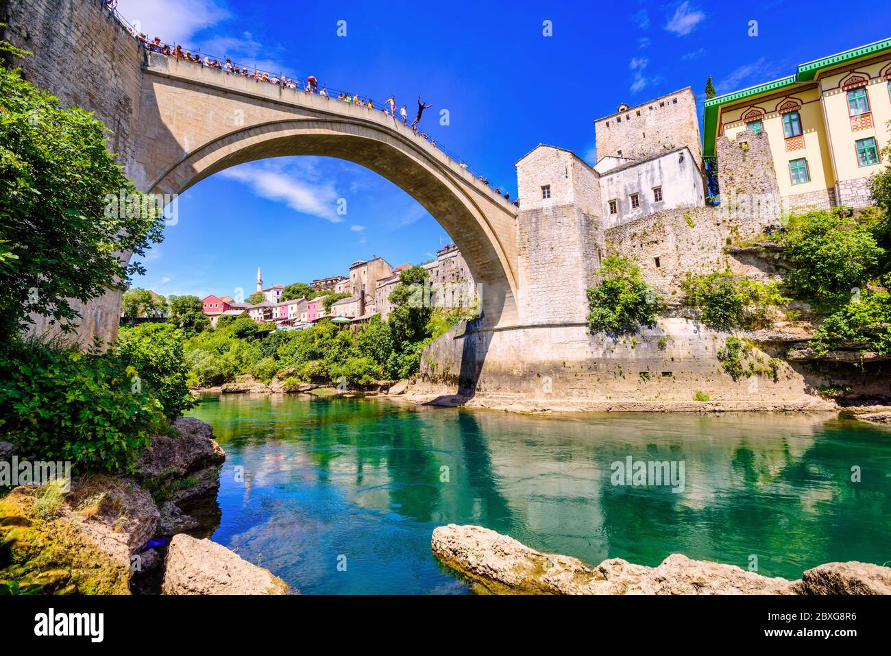 Mostar, Bosnie - 16 juillet 2016 : des gens regardent des garçons sauter de Stary MOST pont vers le bas dans la rivière Neretva dans la vieille ville de Mostar, Bosnie et Herzégo Banque D'Images