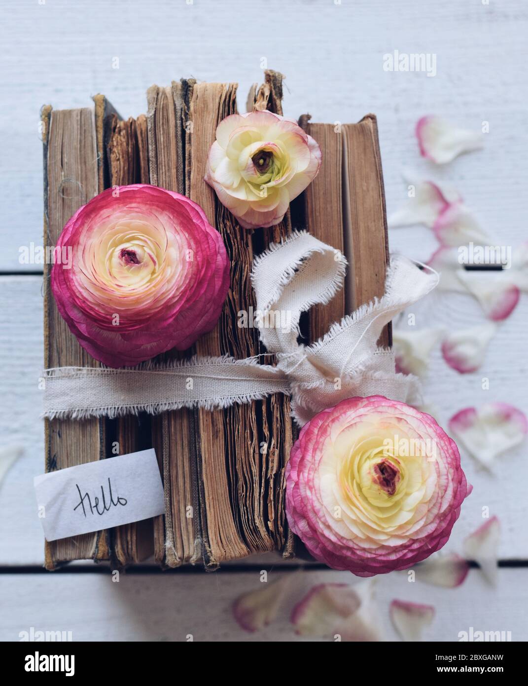 Pile de vieux livres avec fleurs sur une table en bois Banque D'Images