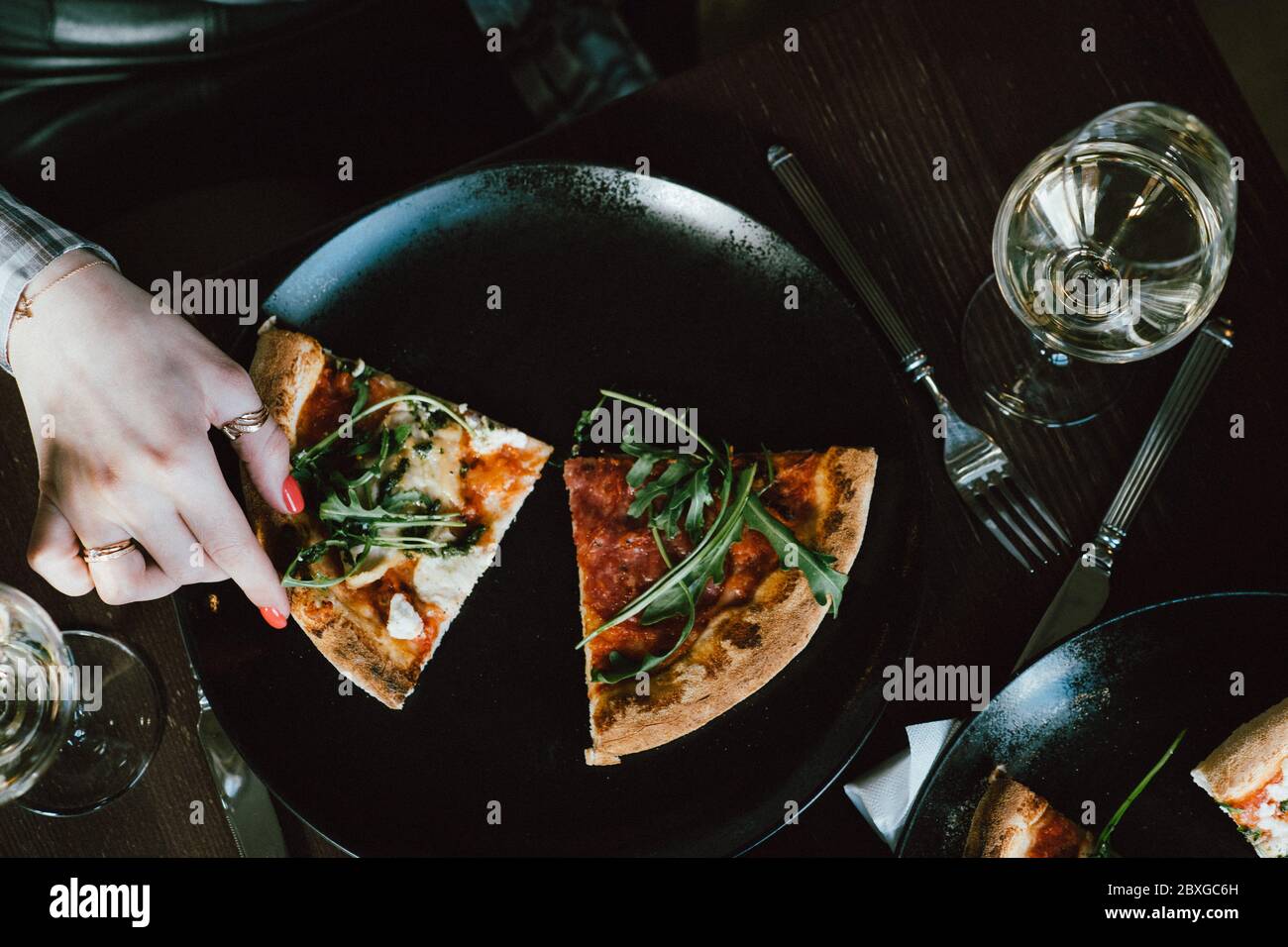 Vue en hauteur d'une femme qui se trouve pour une tranche de pizza Banque D'Images