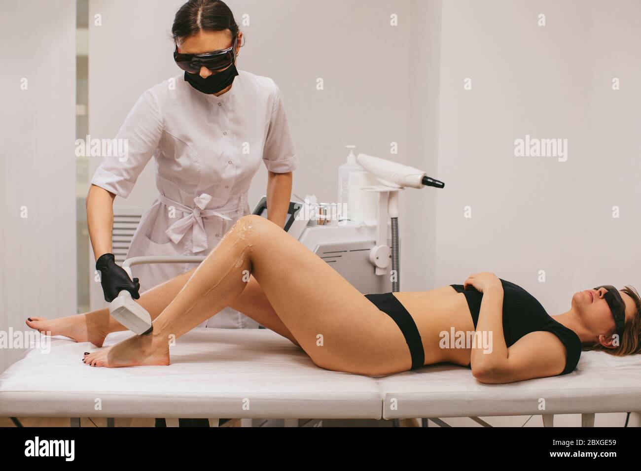 Femme ayant un traitement d'épilation au laser dans un salon de beauté Banque D'Images