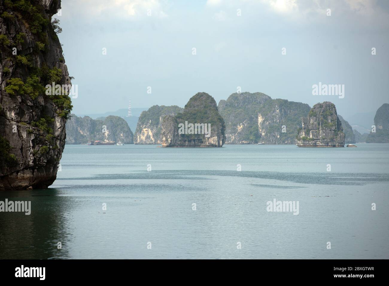 Des eaux tranquilles entourent les imposantes îles de calcaire et les îlots de la baie d'Halong, site classé au patrimoine mondial de l'UNESCO. Vietnam, Asie du Sud-est. Banque D'Images