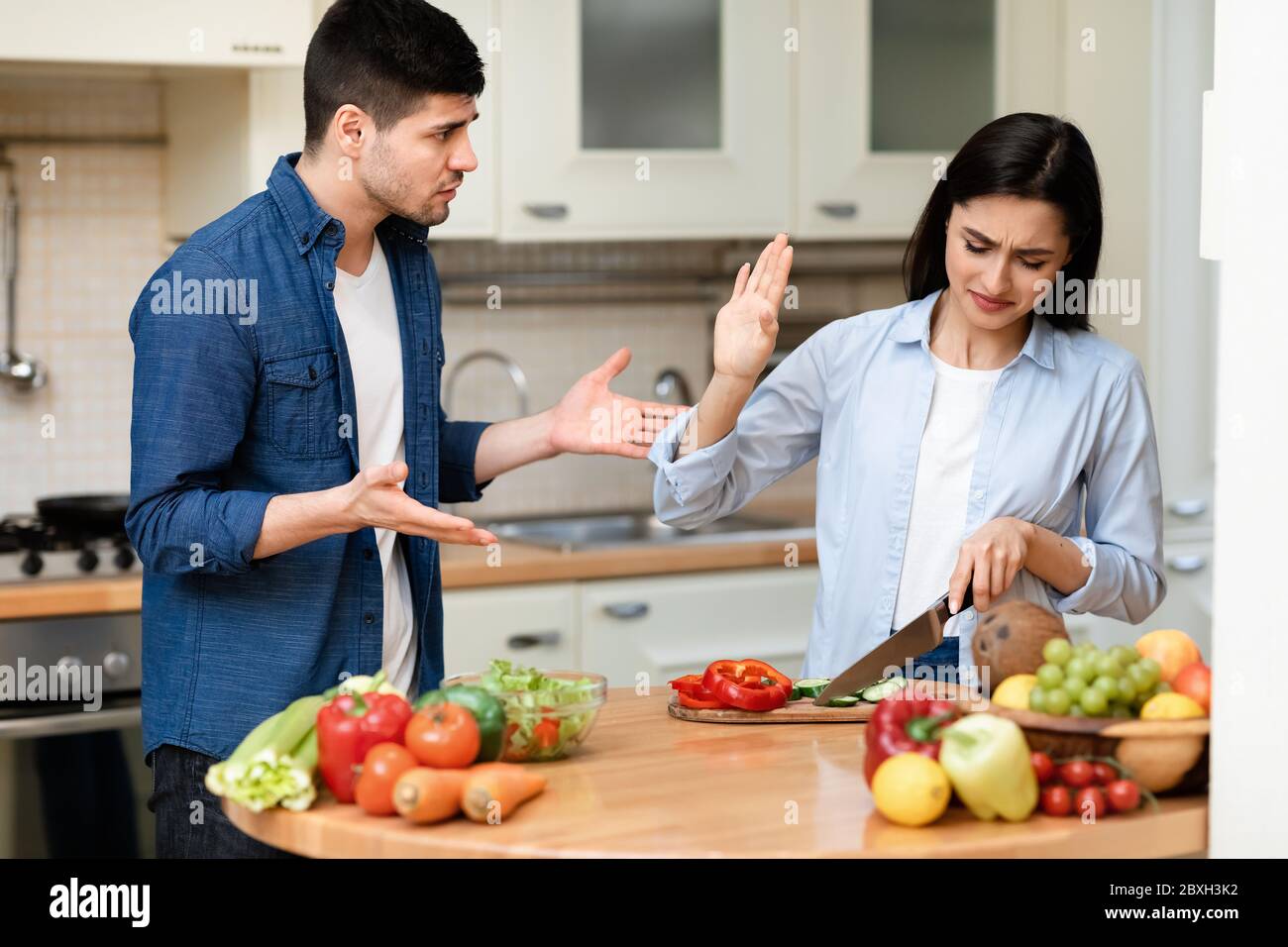 Un jeune couple se disputant dans la cuisine moderne à la maison Banque D'Images