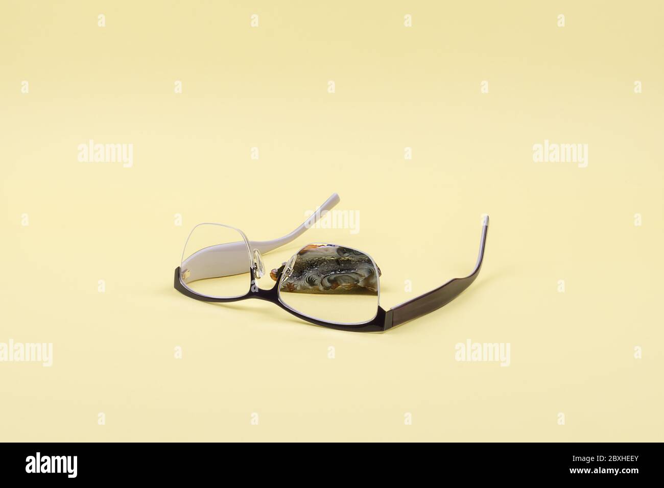 Les lunettes et la Géode agate sur fond jaune. Banque D'Images