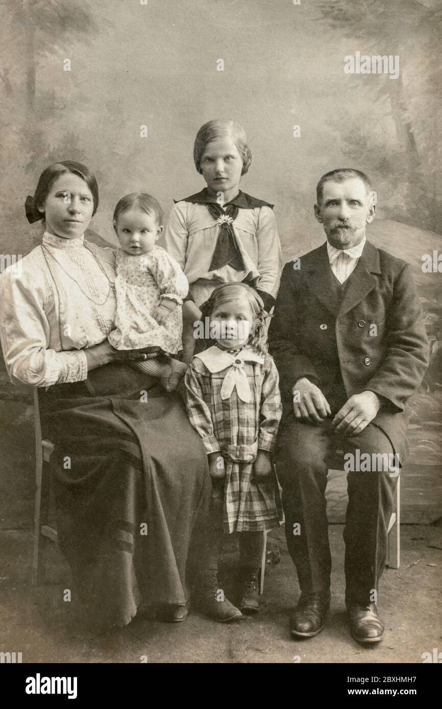 Allemagne - VERS 1910: Un studio familial tourné de homme mature avec une jeune femme et trois enfants en studio. Carte de vue d'époque édouardienne Banque D'Images